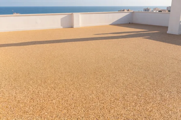 Azotea con stone carpet y vistas al mar: pavimento continuo de árido en toda la superficie